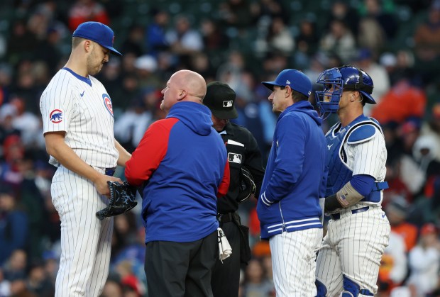 Chicago Cubs starting pitcher Jameson Taillon, left, is checked out by a team trainer after a ball ricocheted off his arm the third inning against the Astros at Wrigley Field on April 24, 2024, in Chicago. (John J. Kim/Chicago Tribune)