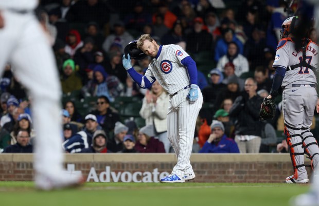 Cubs left fielder Ian Happ (8) takes off his batting helmet after striking out with the bases loaded to end the fourth inning against the Astros at Wrigley Field on April 24, 2024, in Chicago. (John J. Kim/Chicago Tribune)