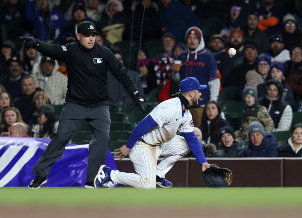 The first base umpire signals a fair ball as Cubs first baseman Michael Busch reaches for an infield single hit by Astros right fielder Kyle Tucker in the fifth inning at Wrigley Field on April 24, 2024, in Chicago. (John J. Kim/Chicago Tribune)