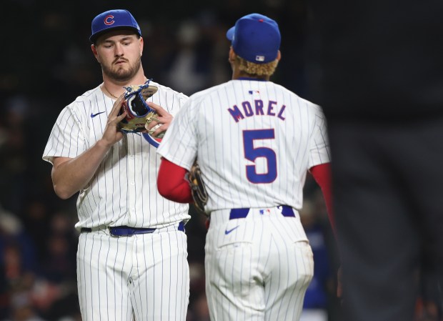 Cubs pitcher Luke Little (43), left, receives a replacement glove tossed to him by third baseman Christopher Morel (5) in the seventh inning against the Astros at Wrigley Field on April 24, 2024, in Chicago. (John J. Kim/Chicago Tribune)