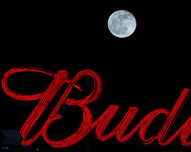 A waning gibbous moon rises above a neon beer sign at Wrigley Field after a 4-3 Cubs win over the Astros on April 24, 2024, in Chicago. (John J. Kim/Chicago Tribune)