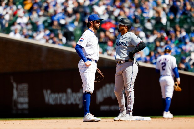 Cubs shortstop Dansby Swanson, left, talks with Marlins second baseman Luis Arraez on April 19, 2024, at Wrigley Field. (Vincent Alban/Chicago Tribune)