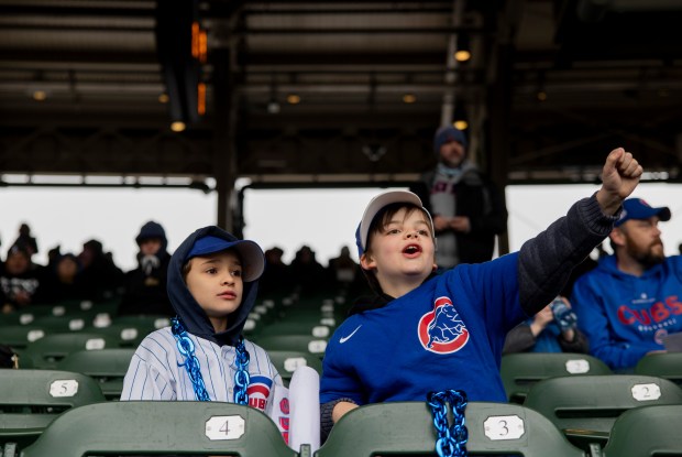 Friends Allan Swanson, 10, left, and Lucas Millard, 9, right, both of Chicago, cheer before the home opening day game between the Chicago Cubs and the Colorado Rockies on April 1, 2024, at Wrigley Field. (Vincent Alban/Chicago Tribune)