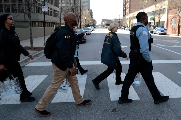 Chicago police, U.S. Secret Service, FBI and other agencies canvass the area near McCormick Place, April 8, 2024, to provide information to businesses and residents about heightened security during this summer's Democratic National Convention. (Antonio Perez/Chicago Tribune)