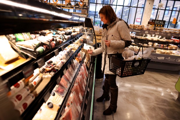 Thea Polancic shops at Dom's Kitchen & Market in Chicago's Lincoln Park neighborhood on Dec. 21, 2022. (Chris Sweda/Chicago Tribune)