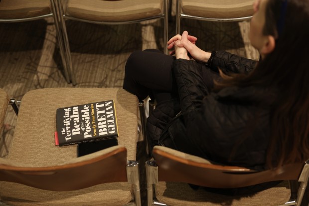 A copy of the book, "The Terrifying Realm of the Possible: Nearly True Stories," is placed on a chair as an attendee listens to actor and author Brett Gelman during a live-audience conversation at Am Shalom in Glencoe. (John J. Kim/Chicago Tribune)