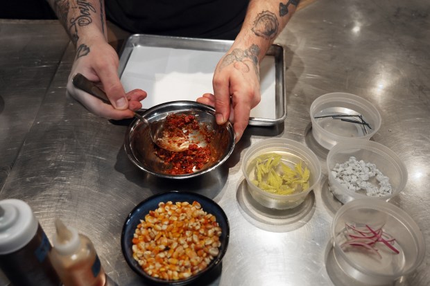 Chef Norman Fenton prepares ingredients for a tostada on April 9, 2024, including guajillo oil, chives, celery leaves, shallot, cilantro, freeze-dried pineapple and red onion. Fenton tries to get the most out of his ingredients. Items like celery leaves and bits of onion are used instead of discarded. (Terrence Antonio James/Chicago Tribune)