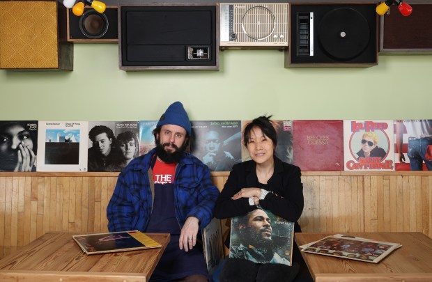 Chefs Johnny Clark and Beverly Kim pose for a portrait with records in their collection at the currently closed Parachute restaurant on North Elston Avenue on March 28, 2024, in Chicago. The chef-partners plan to open a new restaurant in the same space called Parachute Hi-Fi later this summer. (John J. Kim/Chicago Tribune)