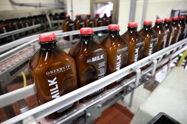 Glass milk bottles move through a bottling line at Oberweis Dairy in North Aurora, March 1, 2017. (Antonio Perez/ Chicago Tribune)