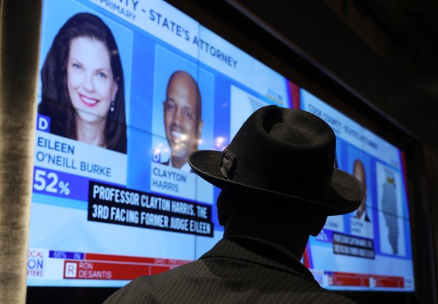 An attendee at the election night gathering for Cook County state's attorney candidate Clayton Harris III watches television news coverage of the race at a restaurant in the 200 block of North Canal Street on March 19, 2024, in Chicago. (John J. Kim/Chicago Tribune)