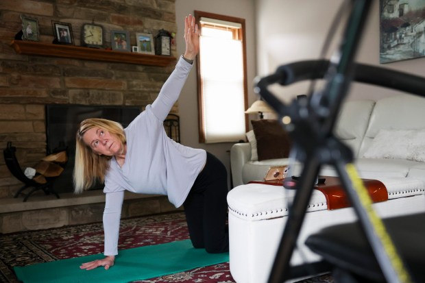 Kim Albin does yoga at her home in Carol Stream on April 18, 2024. Albin, a National Multiple Sclerosis Society district advocacy leader for the state of Illinois, has been living with multiple sclerosis for nearly 30 years. (Eileen T. Meslar/Chicago Tribune)