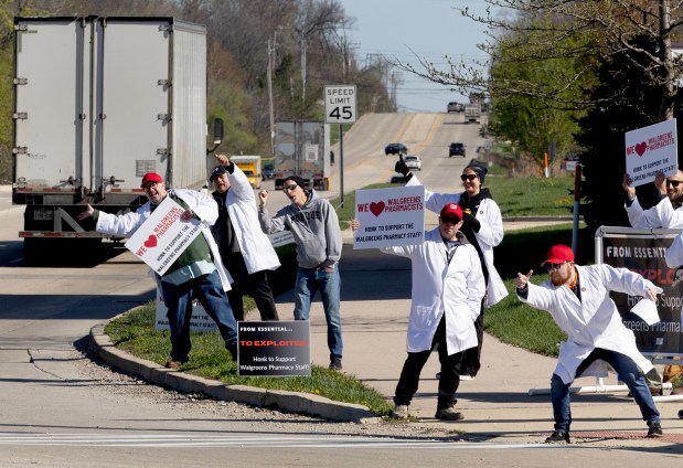 Members of the Laborers International Union of North America (LIUNA) encourage drivers to honk in support of Walgreens pharmacists as they demonstrate outside of a Walgreens store on April 19, 2024, in Bartlett. They were out protesting on behalf of about 900 Illinois Walgreens pharmacists who remain on the job despite not having a contract since May 31, 2023. (Stacey Wescott/Chicago Tribune)