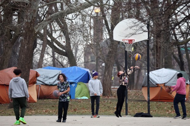 People play basketball near a homeless encampment in Humboldt Park in Chicago on Feb. 7, 2024. (Terrence Antonio James/Chicago Tribune)