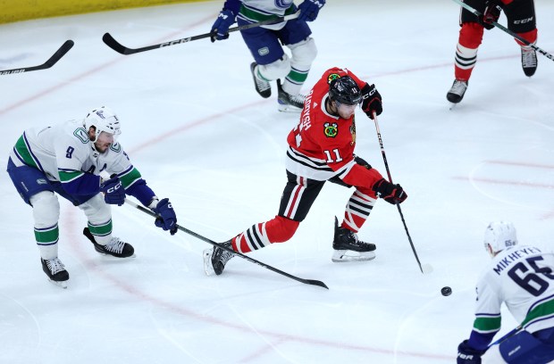 Chicago Blackhawks right wing Taylor Raddysh (11) clears the puck in the second period of a game against the Vancouver Canucks at the United Center in Chicago on Feb. 13, 2024. (Chris Sweda/Chicago Tribune)