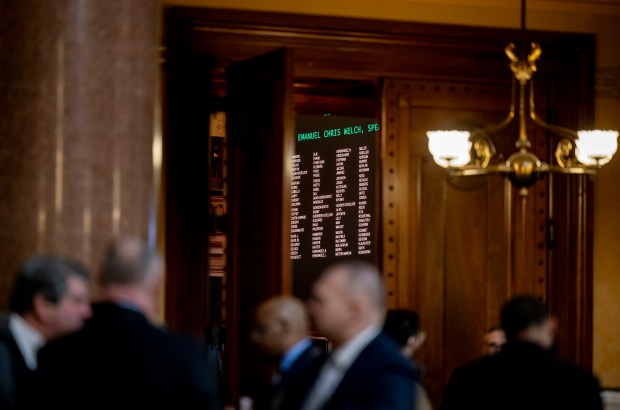 People talk outside the House Chamber while legislators are in session at the Illinois State Capitol on Feb. 20, 2024. (Brian Cassella/Chicago Tribune)