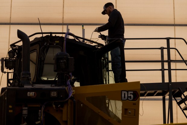 Ryan Schreck, an instrument set up technician, works on a D5 bulldozer in the instrument application center on Wednesday, March 27, 2024, at the Caterpillar Proving Grounds in Washington, Ill. (Vincent Alban/Chicago Tribune)