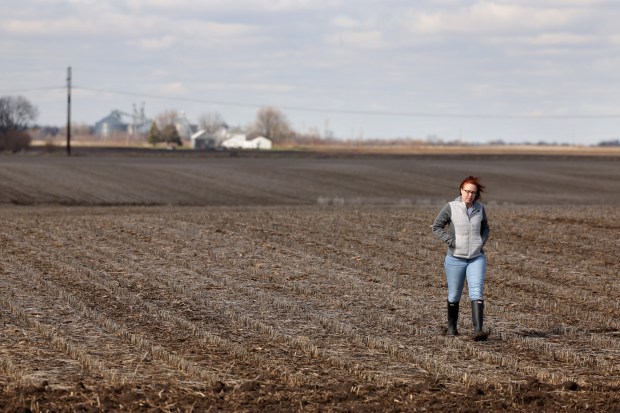 Alice Henkel, a zoning administrator for Lee County, walks in a farm field that will become part of the 5,000 acre Steward Creek Solar farm in Lee County on March 27, 2024. (Stacey Wescott/Chicago Tribune)