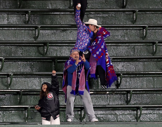 A man receives a kiss after catching a ball in the center field bleachers in the sixth inning of a game between the Chicago Cubs and the Colorado Rockies at Wrigley Field in Chicago on Wednesday, April 3, 2024. (Chris Sweda/Chicago Tribune)