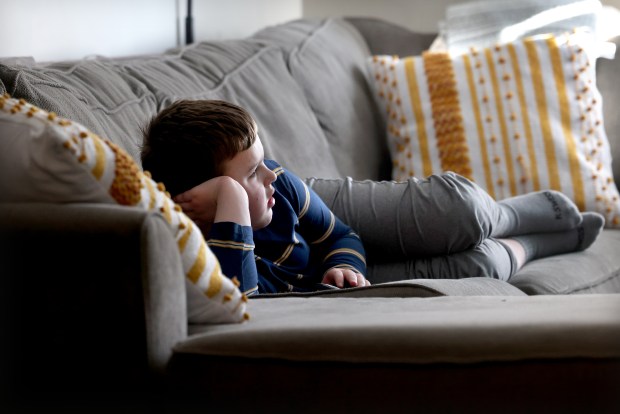 B., 8, who is Autistic, relaxes at his home in Westmont, Feb. 23, 2024. (Antonio Perez/Chicago Tribune)