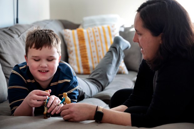 Jennifer Schuh plays with her son B., 8, who is Autistic, at their home in Westmont, Feb. 23, 2024. B. has not been in school for 9 months now after Downers Grove District 58 said they would not accept him because they do not have any aids available and his IEP recommends a therapeutic school. (Antonio Perez/ Chicago Tribune)