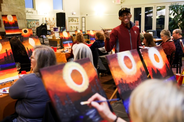 Marquez Scoggin, co-founder and co-owner of Project Human X, leads an eclipse themed painting class on April 5, 2024, at Alto Vineyards in Alto Pass. (Eileen T. Meslar/Chicago Tribune)