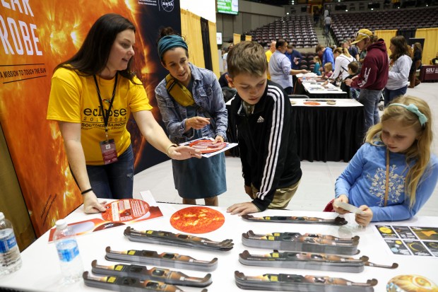 Alisha Harmon, left, speaks to Angela Moll, second from left, and her two children, Lucas, 11, and Lily, 6, during the Crossroads Astronomy, Science and Technology Expo at Southern Illinois University in Carbondale on April 7, 2024.(Eileen T. Meslar/Chicago Tribune)