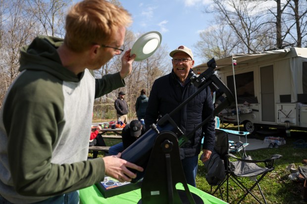 CJ Dugan, a producer at WGN, shows retired WGN-TV meteorologist Tom Skilling his reflector telescope at Dugan's friend's campsite at Little Grassy Lake Campground in Makanda on April 7, 2024. Dugan and his family witnessed the 2017 eclipse with Skilling. (Eileen T. Meslar/Chicago Tribune)