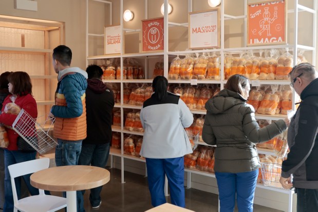 Customers grab baskets of bakery goods at Umaga Bakehouse on April 25, 2024. (Antonio Perez/Chicago Tribune)