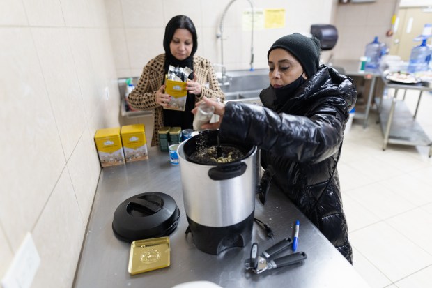 Sam Bawamia, right, and Mona Mahmoud make tea for attendees of an interfaith iftar at the Muslim Education Center in Morton Grove, March 17, 2024. (Troy Stolt/for the Chicago Tribune)