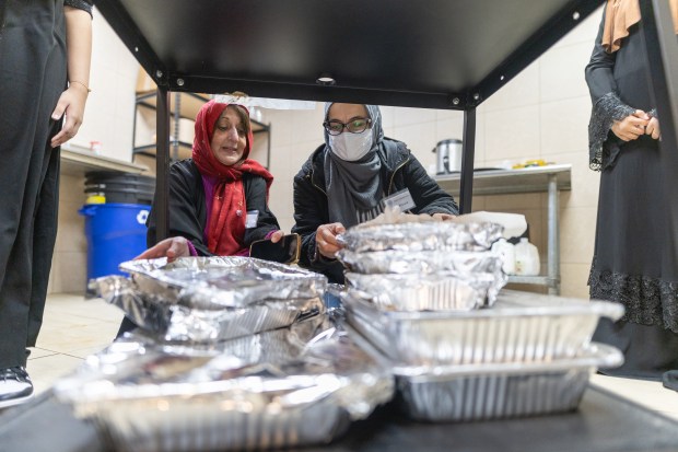 Shakira Bijapuri, left, and Khaula Chaudhry prepare food for a Ramadan interfaith iftar at the Muslim Education Center in Morton Grove on March 17, 2024. (Troy Stolt/for the Chicago Tribune)