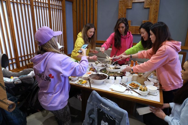 Veronica Palumbo, from left, Abby Laczkowski, Tammy Boyer, Stephanie Xu, Emma Park and Elizabeth Tye are part of a group of friends who meet at the same hotpot restaurant, Qiao Lin Hotpot on South Jefferson Street in Chicago, every week to share food and conversation on March 20, 2024. (Terrence Antonio James/Chicago Tribune)