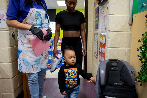 Joziah McAllister walks out of a classroom with his mother, Irmony Sneed, behind him, on March 5, 2024, at the Blanche Foxworthy Infant Care Center. (Vincent Alban/Chicago Tribune)