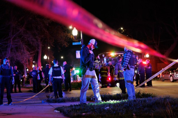 Officers and paramedics work the scene where multiple people were shot near the 5200 block of South Damen Avenue, April 13, 2024, in Chicago. (Armando L. Sanchez/Chicago Tribune)