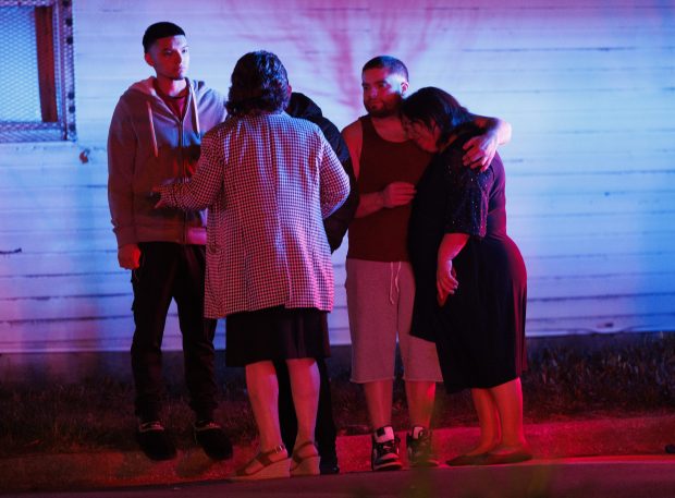 People console one another at the scene where several people were shot near the 5200 block of South Damen Avenue, April 13, 2024, in Chicago. (Armando L. Sanchez/Chicago Tribune)