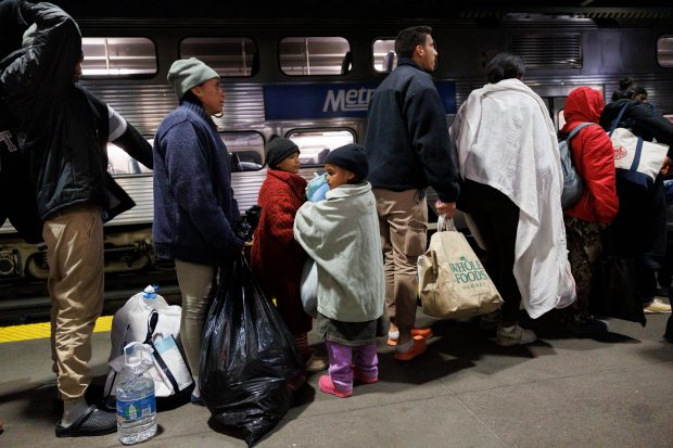 Venezuelan migrants Leonardo Ruiz, from left, his wife Stefania Rengifo and their children wait in line after riding a Metra train from Wilmette to Ogilvie Transportation Center, April 3, 2024, in Chicago. (Armando L. Sanchez/Chicago Tribune)