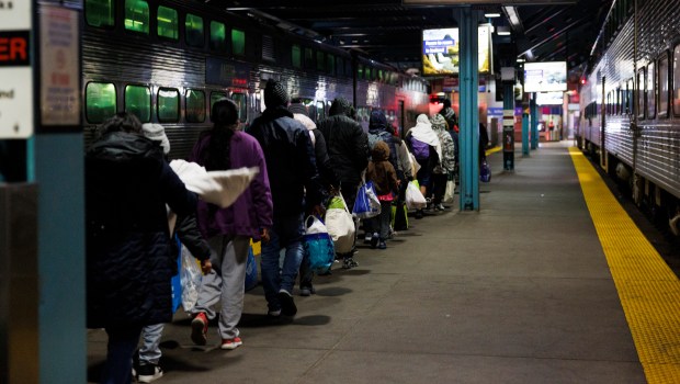 After riding a Metra train from Wilmette to Chicago's Ogilvie Transportation Center, migrants follow Metra officials to the exit on April 3, 2024. (Armando L. Sanchez/Chicago Tribune)