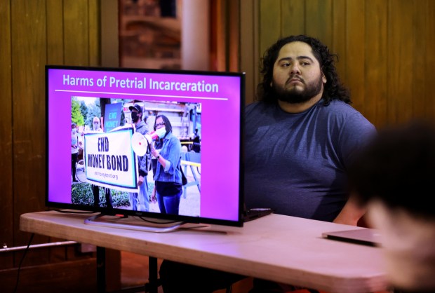 12th District Police Council board member Leonardo Quintero sits behind a screen as Briana Payton (not pictured), director of policy and advocacy at Chicago Appleseed Center for Fair Courts, speaks on the topic of the Pretrial Fairness Act to a small group of people attending a monthly meeting of the 12th District Police Council at the Union Park field house on Chicago's Near West side on March 20, 2024. (Chris Sweda/Chicago Tribune)