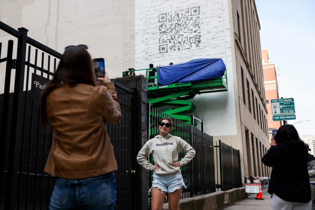 Nicole Granato takes a photo of Peyton Granato in front of a QR code mural in River North on April 16, 2024, The QR code links to a Taylor Swift web page. (Eileen T. Meslar/Chicago Tribune)