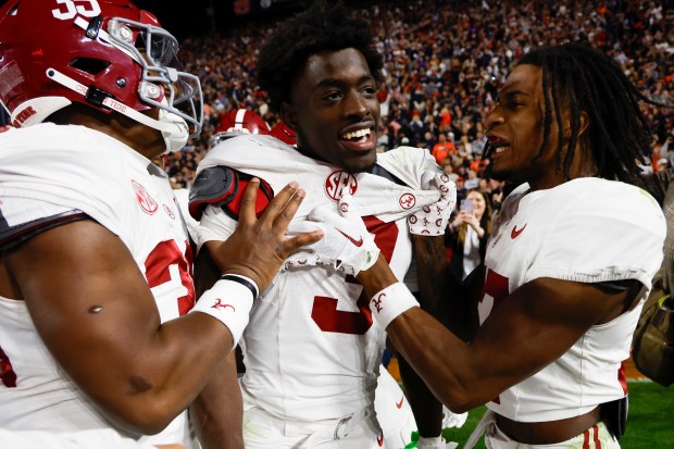 Alabama defensive back Terrion Arnold (3) celebrates with linebackers Jeremiah Alexander, left, and Trezmen Marshall, right, after an interception in the second half against Auburn on Nov. 25, 2023. (AP Photo/Butch Dill)