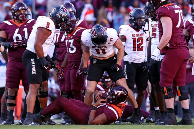 N.C. State linebacker Payton Wilson (11) looks down at Virginia Tech quarterback Kyron Drones after a sack at Lane Stadium. (Peter Casey/USA Today)