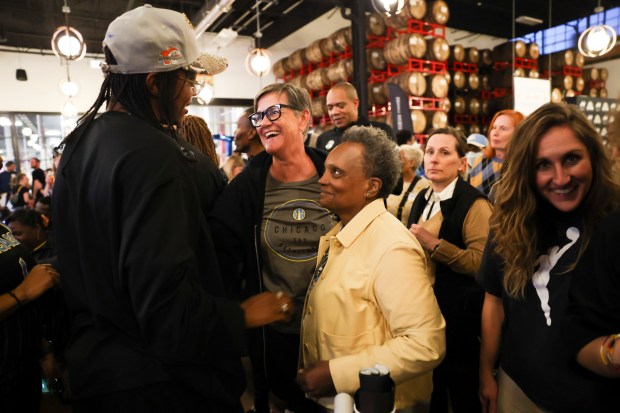 Former mayor Lori Lightfoot and her wife Amy Eshleman speak to Chicago Sky player Diamond DeShields during Chicago Sky's WNBA draft watch party at Revolution Brewing in Chicago on April 15, 2024. (Eileen T. Meslar/Chicago Tribune)