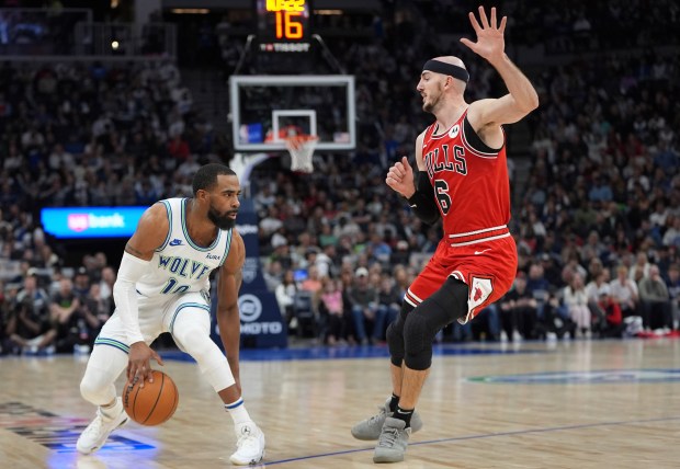 Minnesota Timberwolves guard Mike Conley (10) works toward the basket as Chicago Bulls guard Alex Caruso (6) defends during the second half of an NBA basketball game Sunday, March 31, 2024, in Minneapolis. (AP Photo/Abbie Parr)