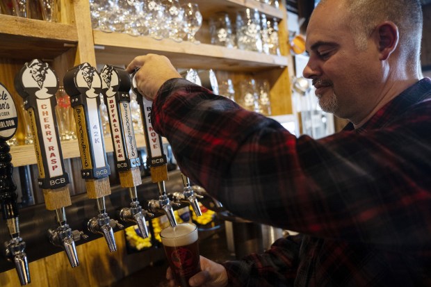 Buffalo Creek Brewing owner Mike Marr is shown on Oct. 21, 2022, pouring a "Bad Move," a U-Haul orange-colored honey nut brown ale that commemorates a crash into the nearby Long Grove covered bridge.