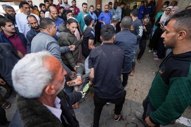 Palestinians carry a wounded person following an Israeli airstrike near the Al Aqsa hospital in Deir al Balah, Gaza Strip, Sunday, March 31, 2024. (AP Photo/Abdel Kareem Hana)