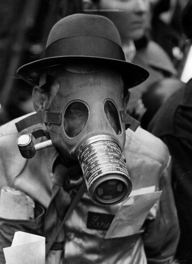 A participant at the first Earth Day rally at the Civic Center in Chicago wears a gas mask with a pipe with a cover on it coming out of his mouth on April 22, 1970.