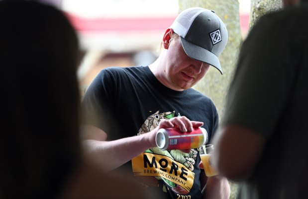 Christian Boduch, server with MoRE Brewing Company of Villa Park, Huntley, Bartlett and of Fort Wayne, Indiana, pours samples at the Craft Beer Festival in Long Grove on April 27, 2024. (Karie Angell Luc/Lake County News-Sun)