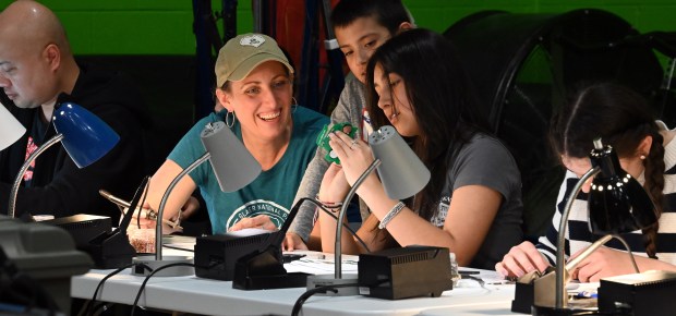 From left to right, at the Build-a-Blinkie.org station are parent Kelly McCracken of Grayslake and children Maverick Mora, 8, a third-grader and Xoey Mora, 14, a ninth-grader at Maker Faire Lake County on April 13, 2024 at the College of Lake County In Grayslake.