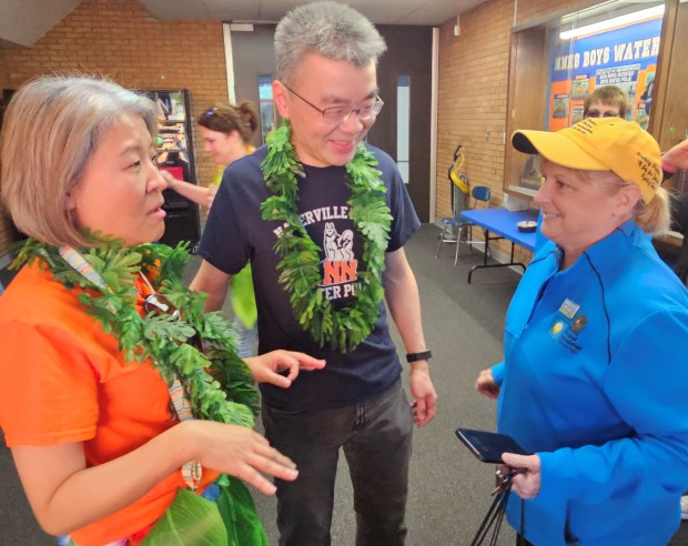 Naperville residents Angela and Wilson Lam, left and center, speak with Kelli Ritschel Boehle, founder of the Nikolas Ritschel Foundation, before her group awarded the couple's son, Adrian, with a family a trip to Hawaii. Adrian, 19, has undergoing cancer treatments for the past year and was informed that his wish was granted during a surprise event Tuesday at Naperville North High School. (David Sharos/Naperville Sun)