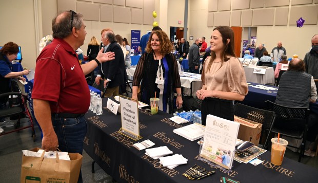 For left to right, Howard Hoffman of Buffalo Grove, Leora Eidenberg of Wheeling, marketing coordinator with The Wealshire of Lincolnshire and Jessica Banks, chief marketing officer with The Wealshire, at the annual Senior Expo at the Community Arts Center (225 McHenry Road) in Buffalo Grove on April 16, 2024. (Karie Angell Luc/Pioneer Press)