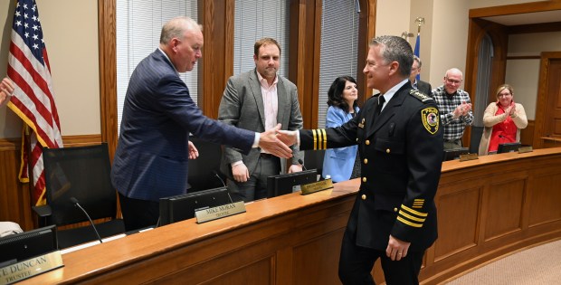 John Burke, of Arlington Heights, left, greets members of the Barrington Village Board after being sworn in as chief of police April 8, 2024 at Village Hall in Barrington. (Karie Angell Luc/Pioneer Press)